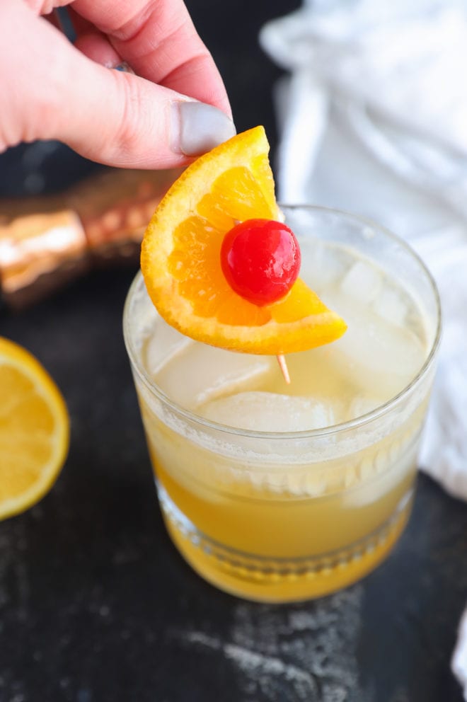 Garnishing a whiskey sour cocktail
