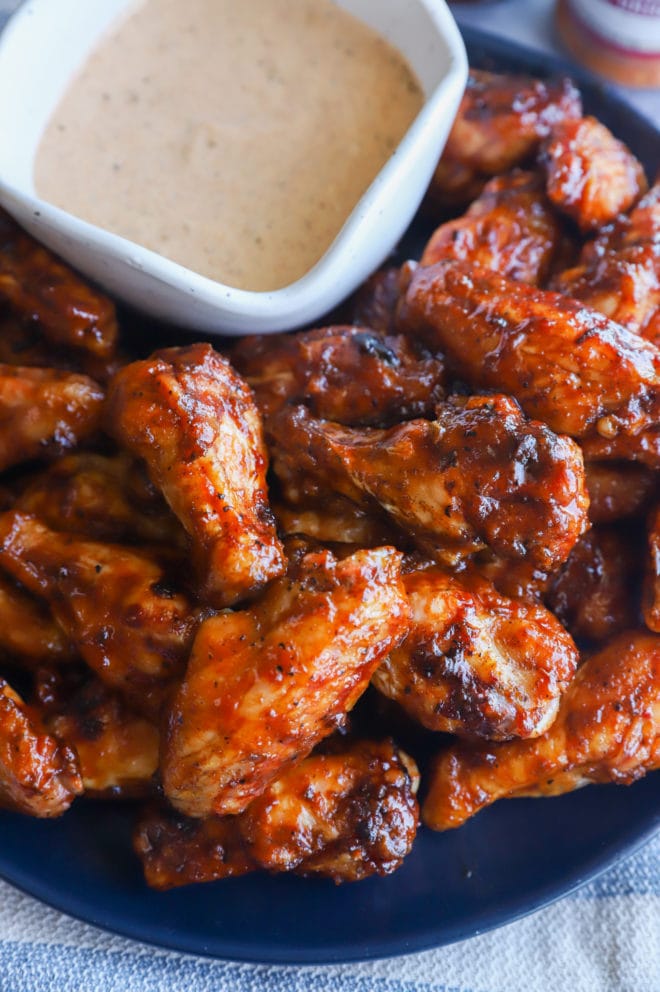 Grilled honey bbq wings on a platter with sauce image