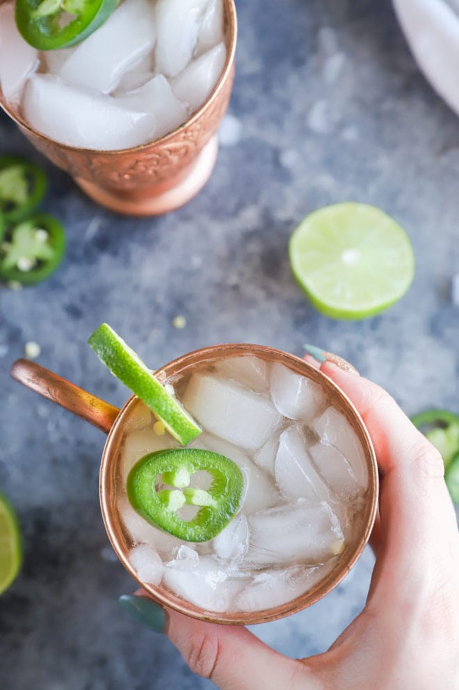 Hand holding mug with jalapeno mexican mule