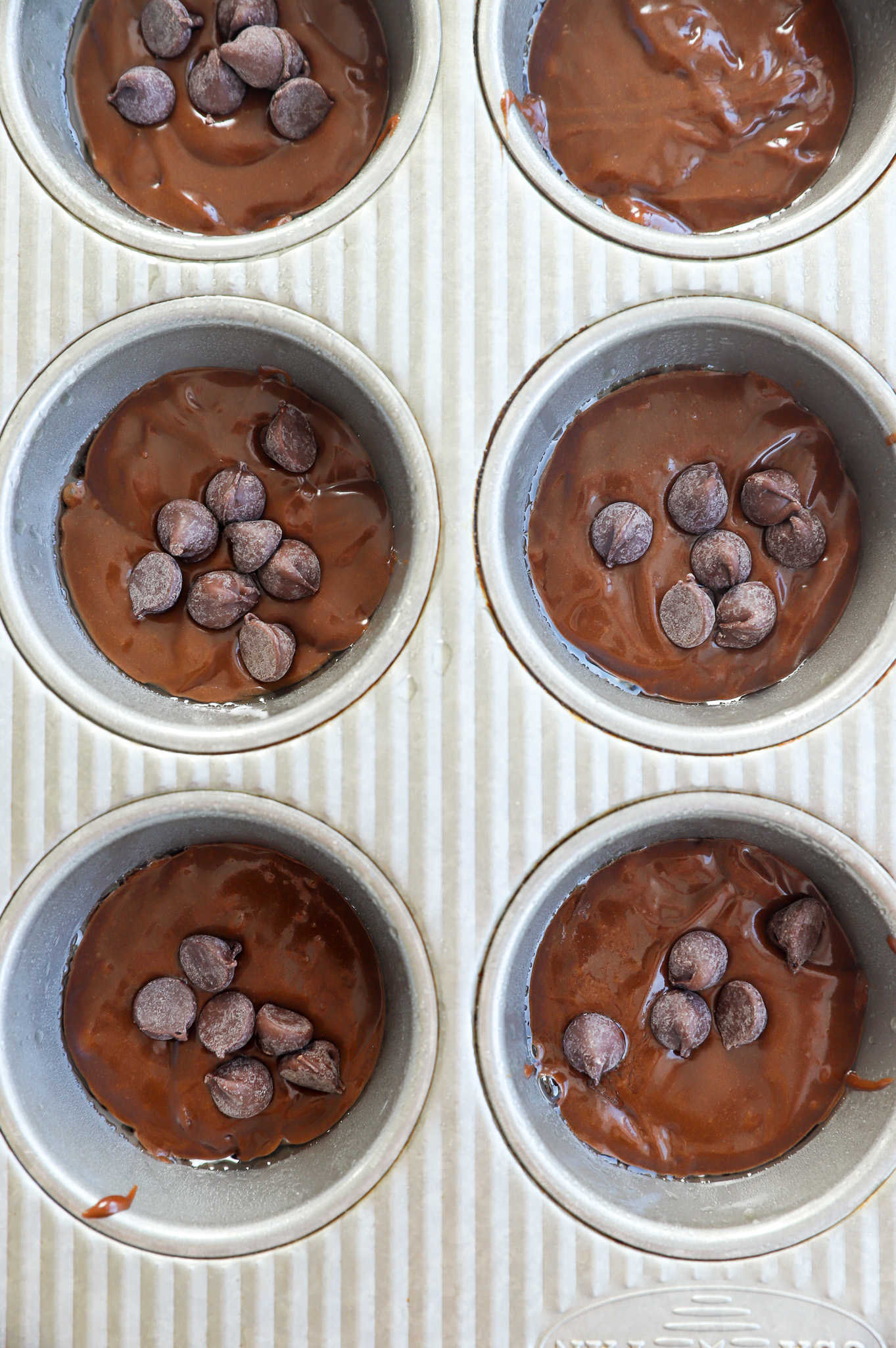 Overhead image of cake batter in muffin tins before baking