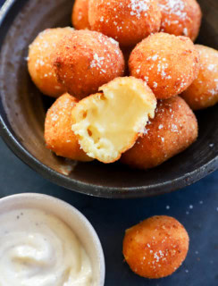 Cheesy croquette cut in half with gooey melted cheese inside