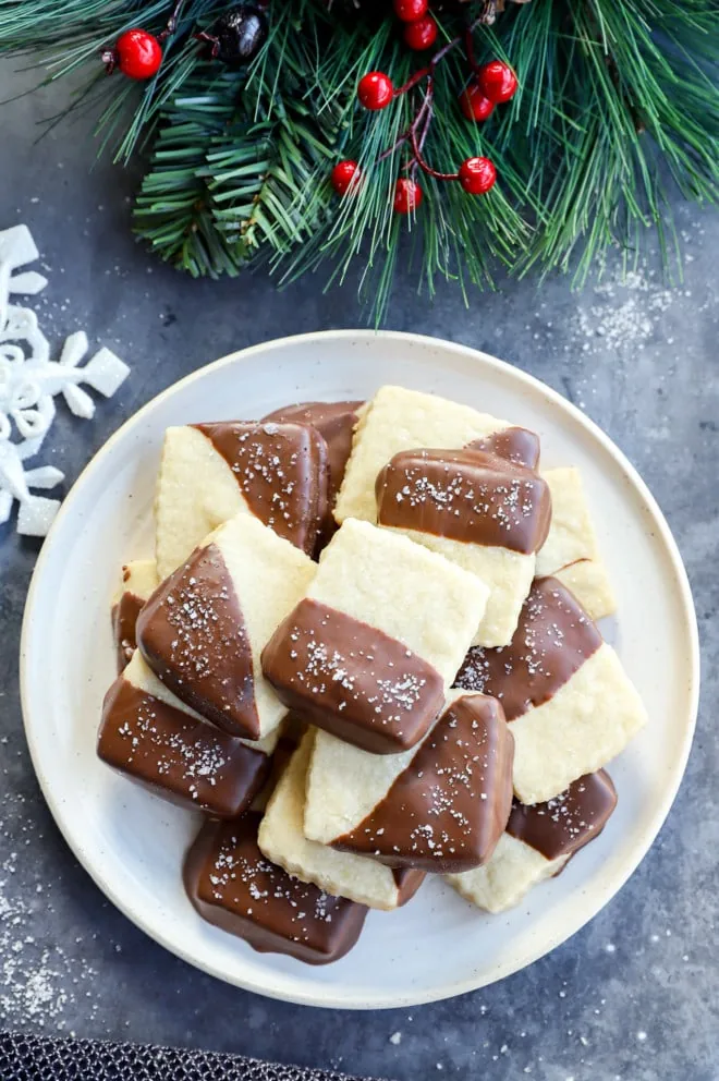 Plate of milk chocolate dipped shortbread cookies with holiday decorations