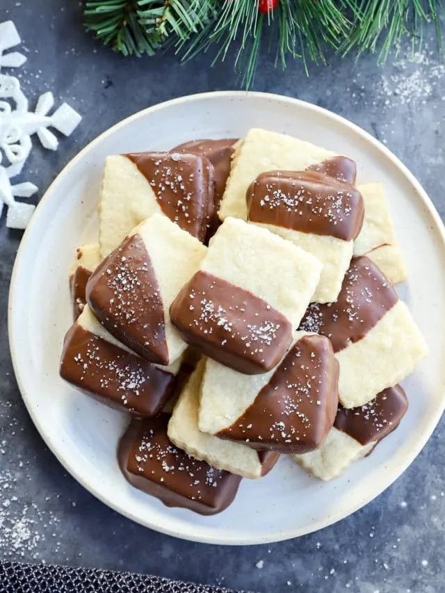 Plate of milk chocolate dipped shortbread cookies with holiday decorations