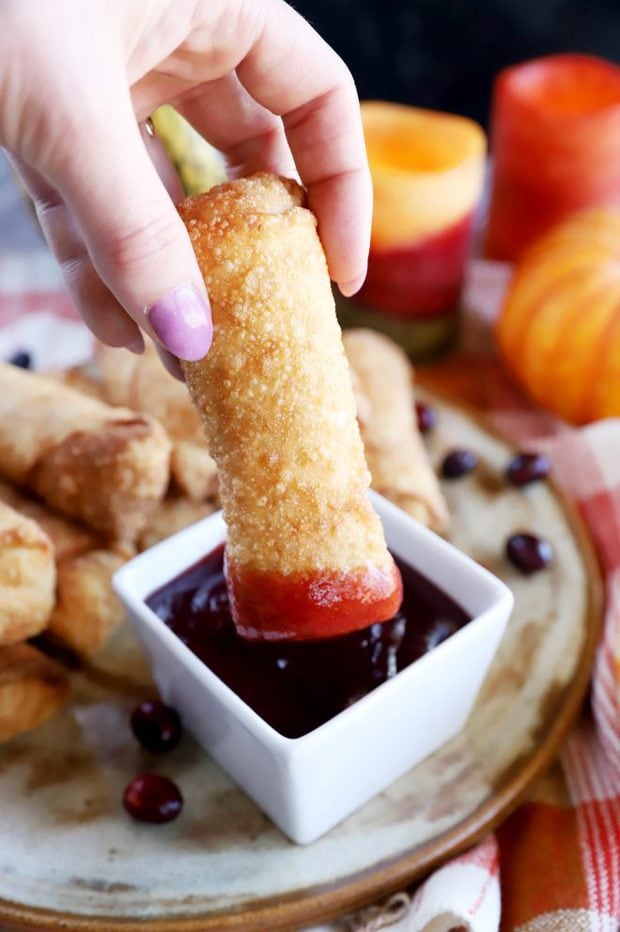 Dipping an egg roll in cranberry sauce image