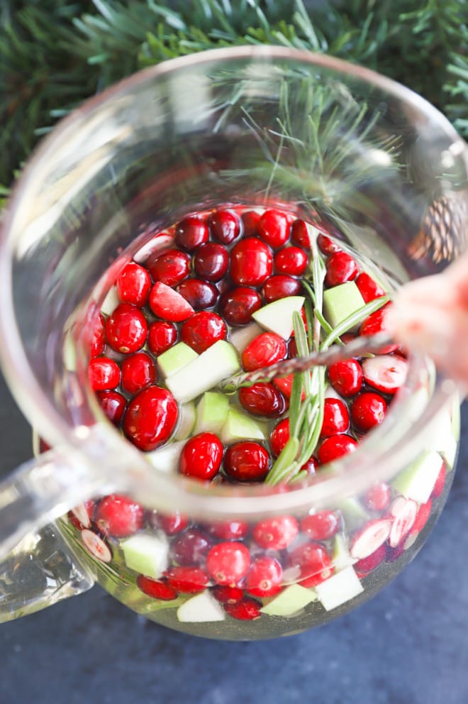 stirring christmas sangria with a spoon