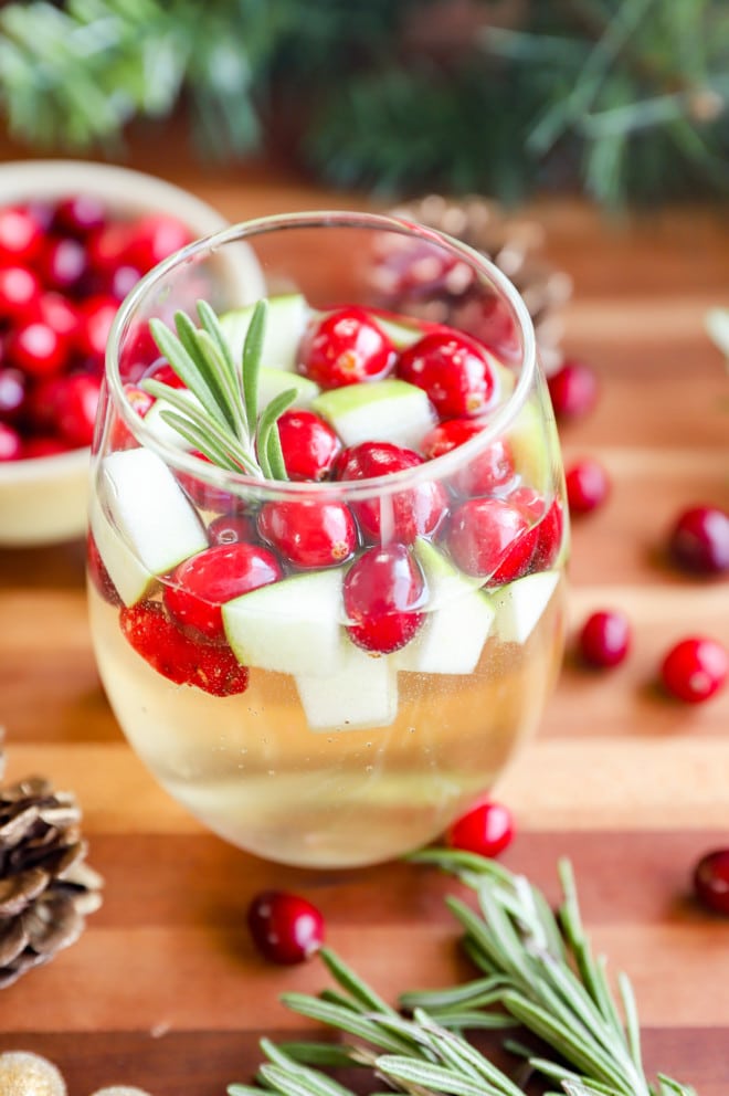 christmas sangria in a wine glass with rosemary