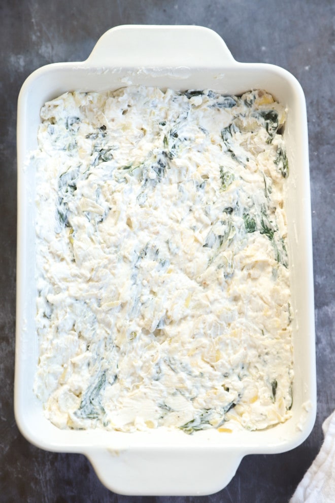 spinach artichoke cheese dip before baking in casserole dish