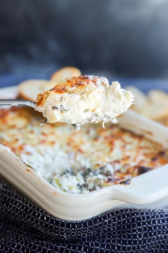 hot spinach artichoke goat cheese dip on spoon