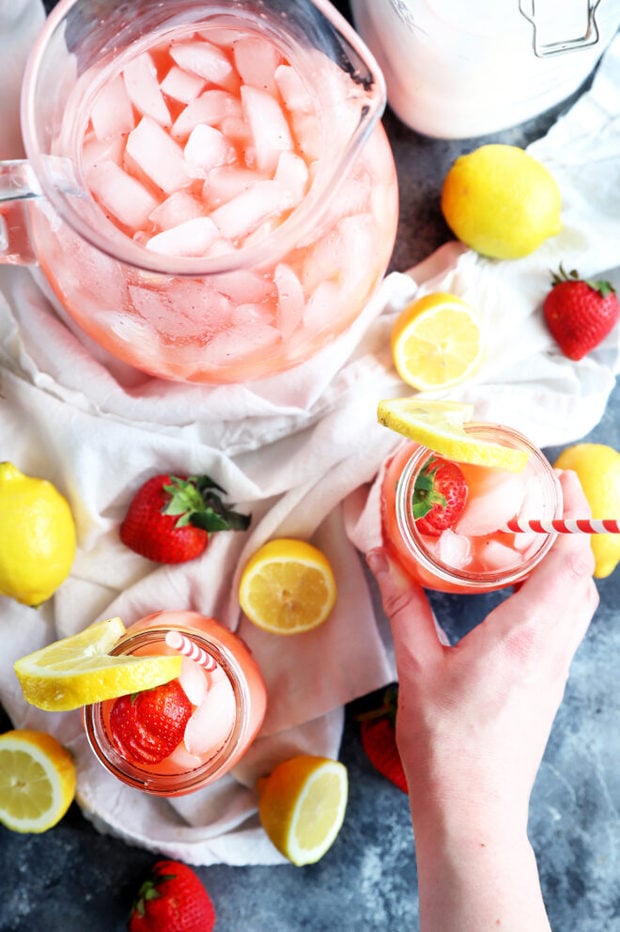 Hand holding jar of strawberry lemonade photo