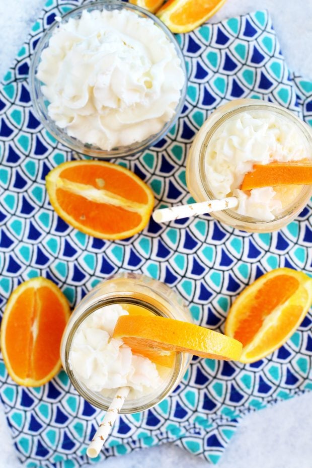 Image of orange cocktails in glasses with whipped cream summer cocktail