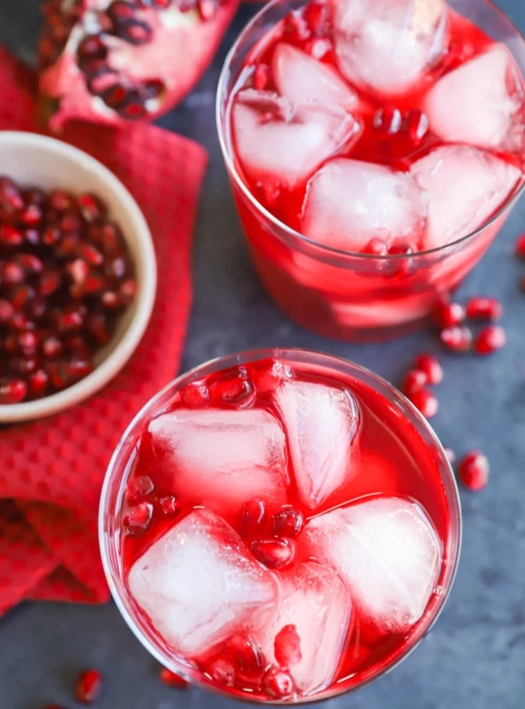 image of glasses with pomegranate seeds and a gin drink