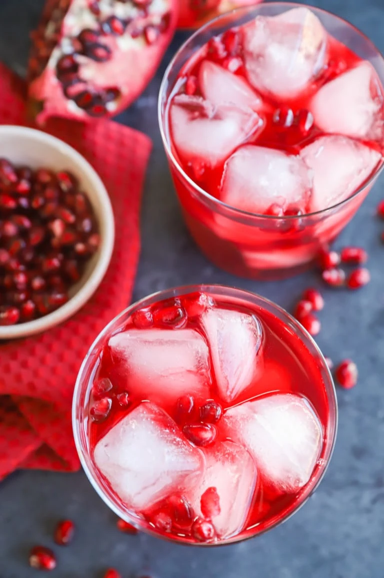 image of glasses with pomegranate seeds and a gin drink