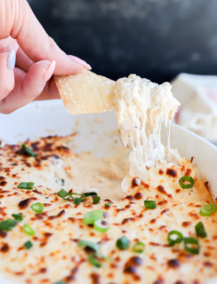 Chip lifting out crab dip from casserole dish image