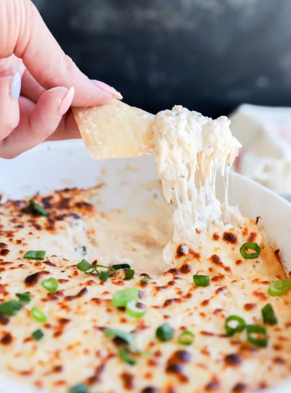 Chip lifting out crab dip from casserole dish image