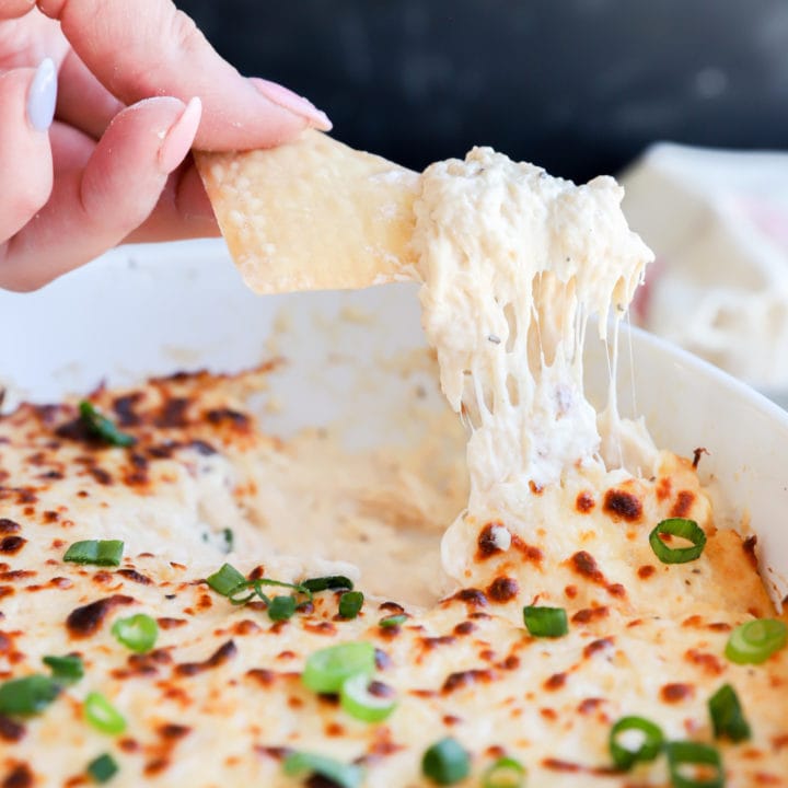 Chip lifting out crab dip from casserole dish image