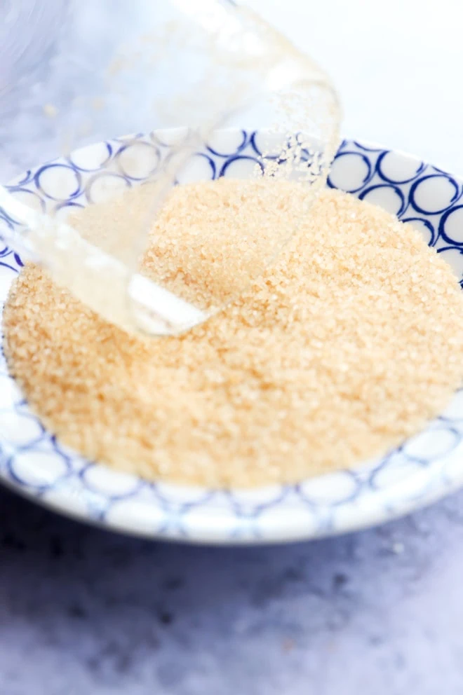 rimming a cocktail glass with raw sugar