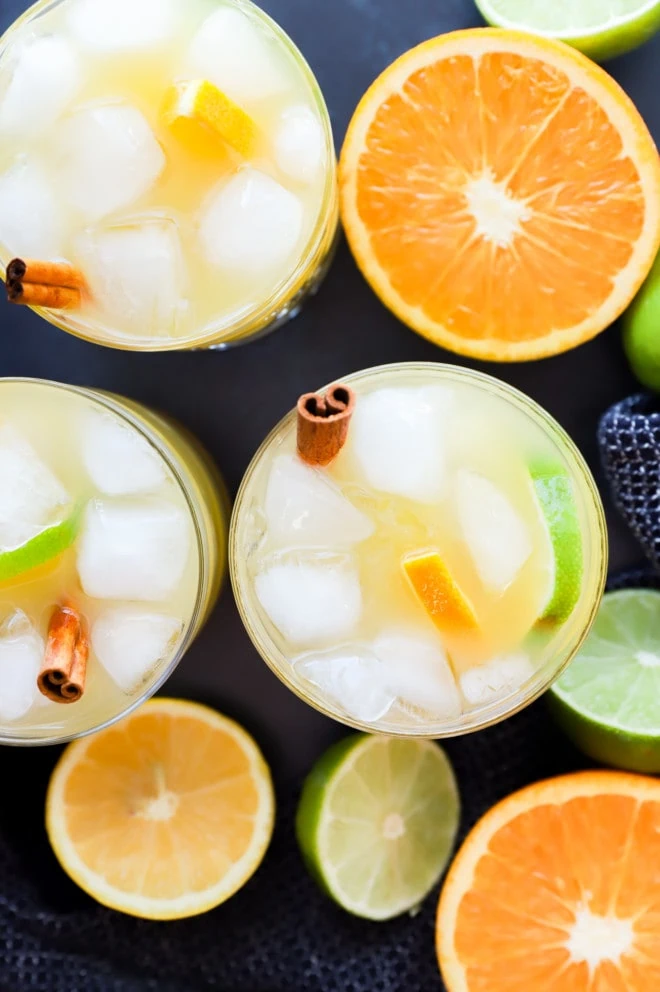 image of big batch cocktail in glasses with citrus fruit halves