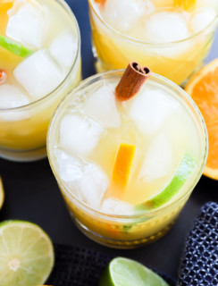 spiced rum punch in glasses with cinnamon sticks