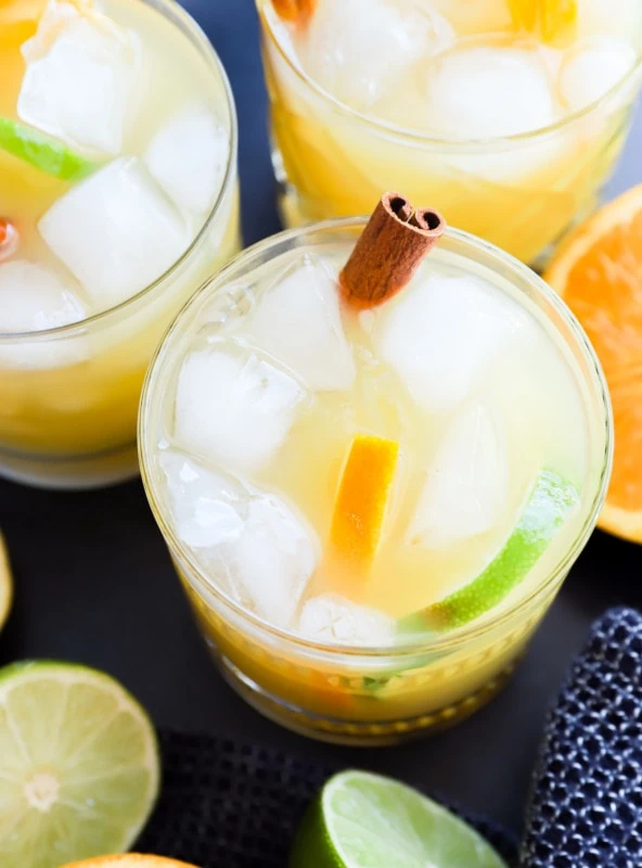 spiced rum punch in glasses with cinnamon sticks