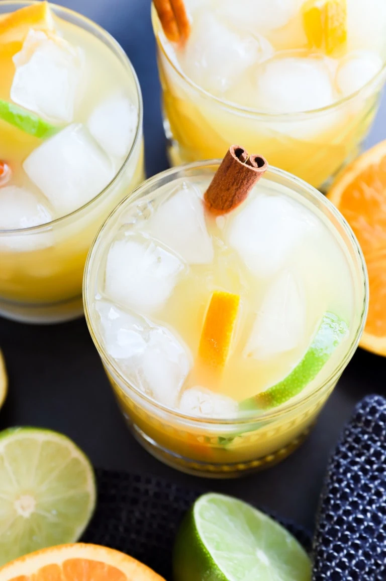 spiced rum punch in glasses with cinnamon sticks