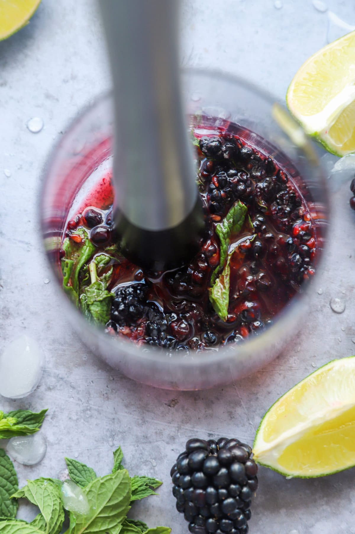 Muddle blackberries with mint in a cocktail glass image