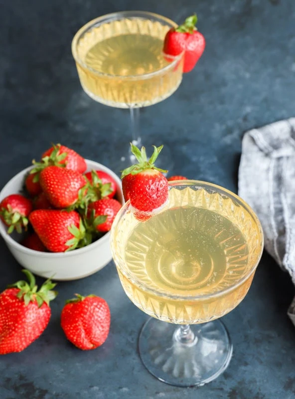 strawberry champagne cocktail in coupe glasses with fresh berries