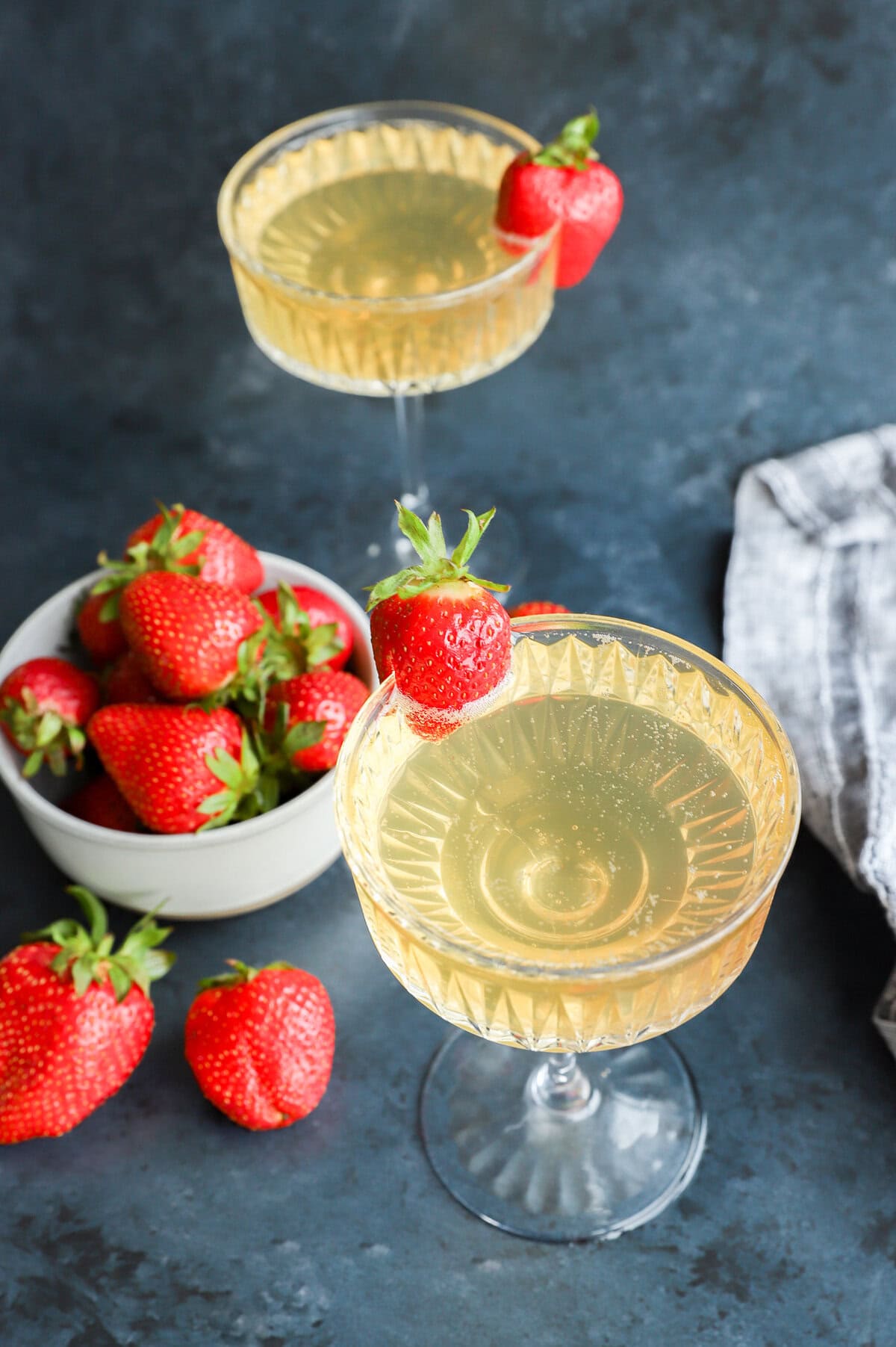 strawberry champagne cocktail in coupe glasses with fresh berries