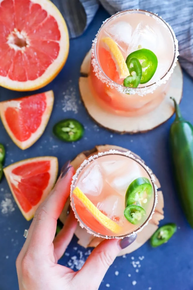 Hand holding a salty dog cocktail in a glass