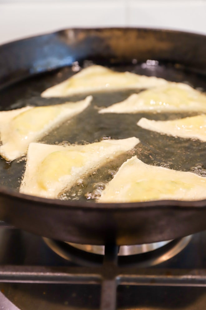 Frying jalapeno popper wontons in a cast iron skillet image