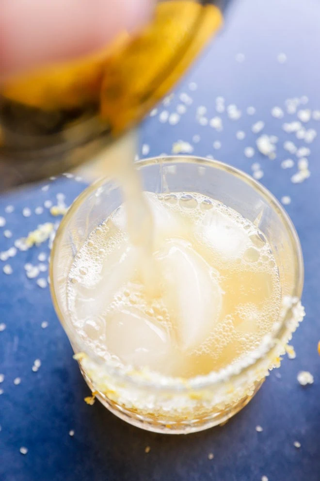 Pouring margarita into a glass of ice image