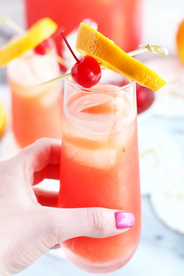 Hand holding champagne flute with cocktail image