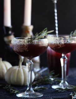 Spooky Pomegranate Mezcal Cocktail from the side with candlesticks