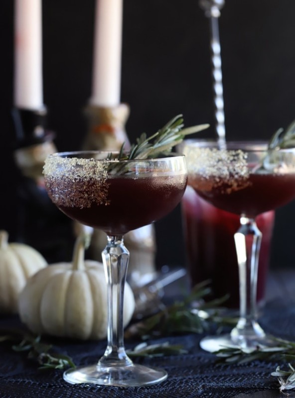 Spooky Pomegranate Mezcal Cocktail from the side with candlesticks