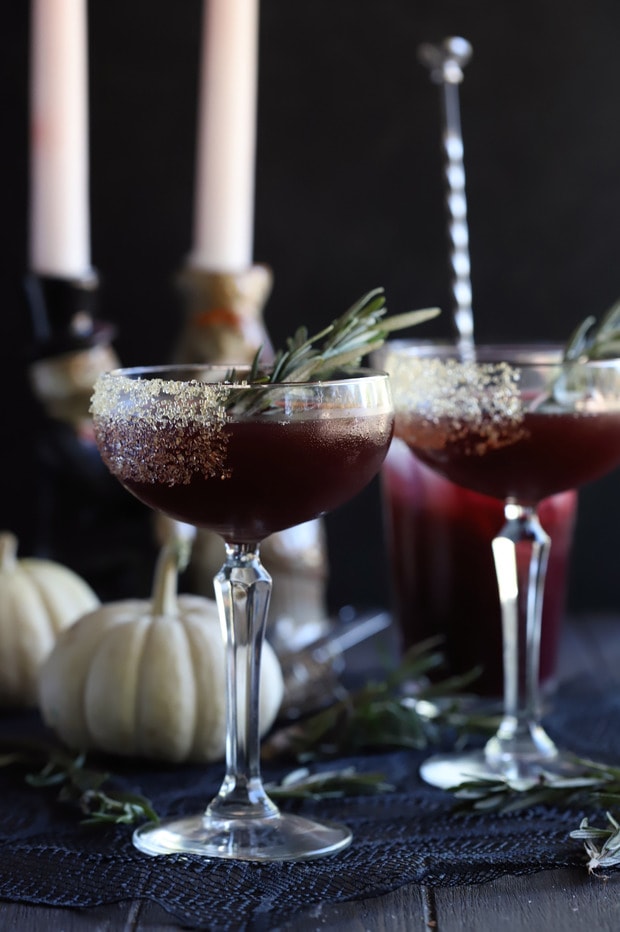 Spooky Pomegranate Mezcal Cocktail from the side with candlesticks