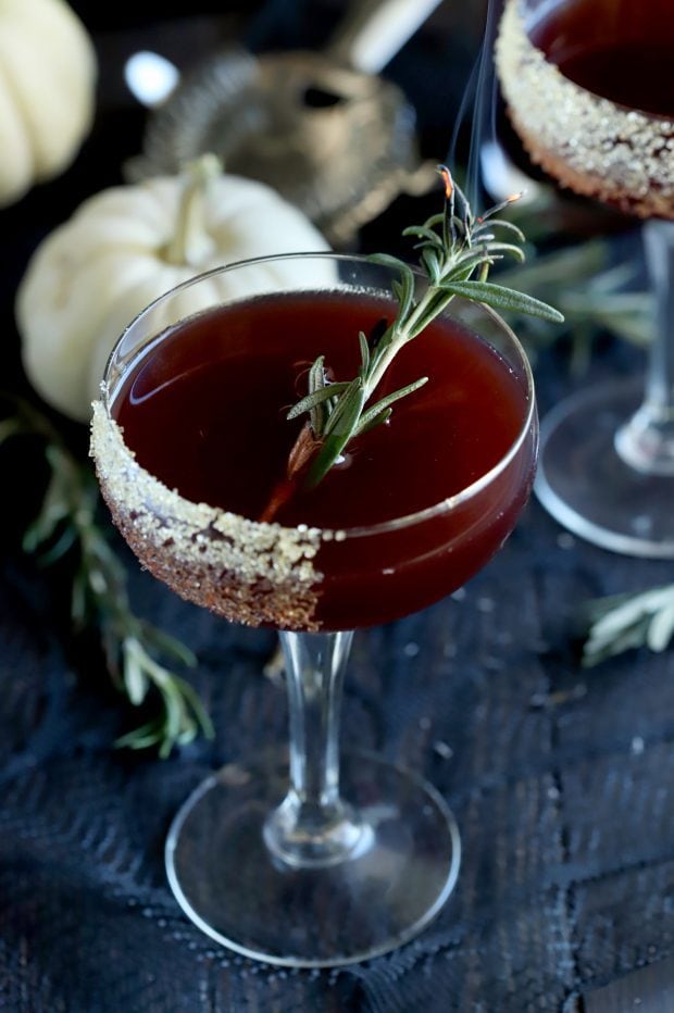 Spooky Pomegranate Mezcal Cocktail with smoking rosemary in the coupe glass