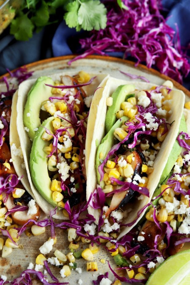 a couple Charred Corn Chicken Avocado Tacos