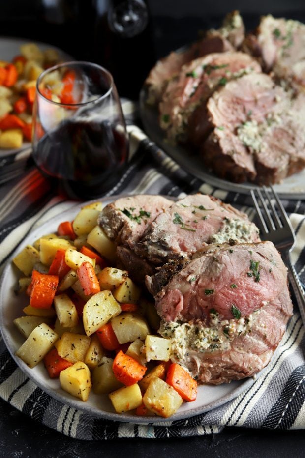 Sliced stuffed leg of lamb with vegetables and wine