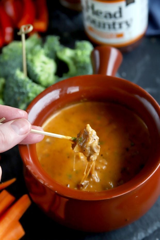 Apple piece being dipped into short ribs BBQ fondue