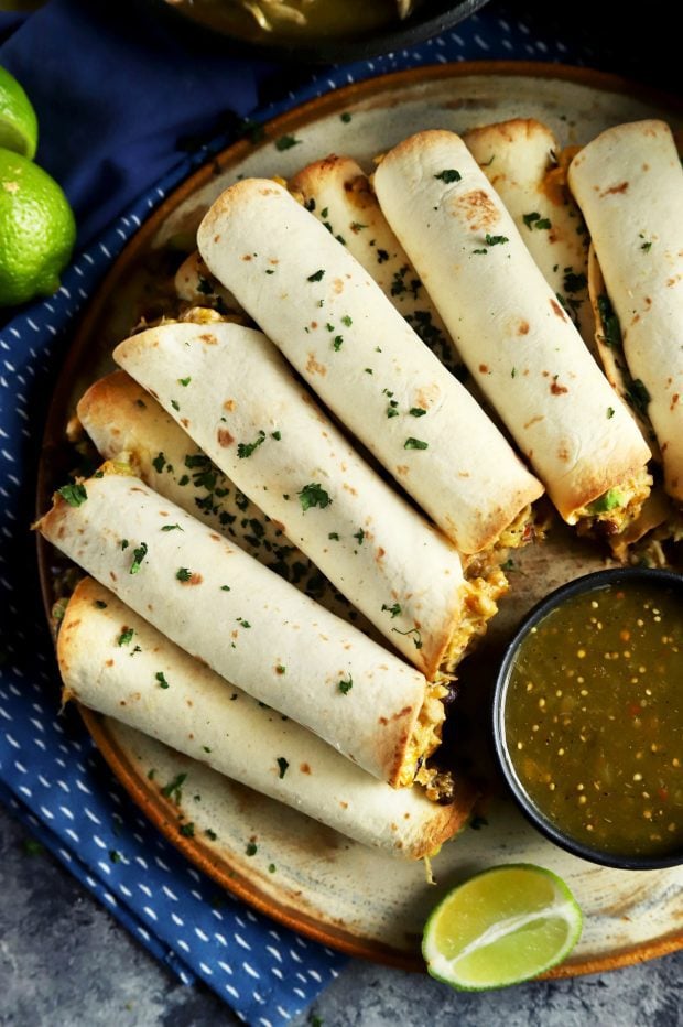 Creamy chicken taquitos piled together on a plate