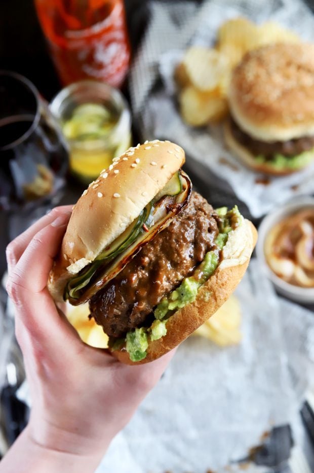 Holding a grilled gourmet burger