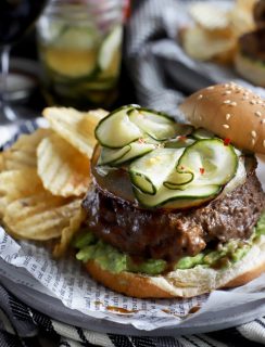 Burger with pickles, avocado, and chips