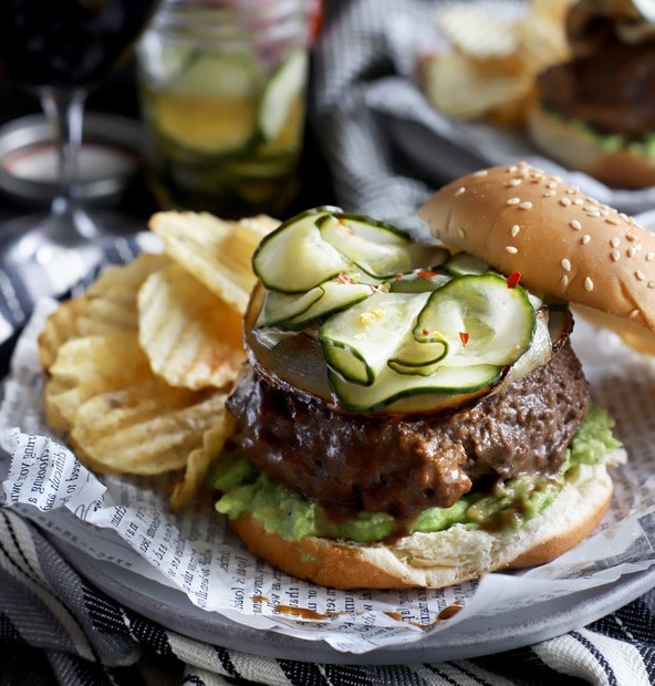 Burger with pickles, avocado, and chips