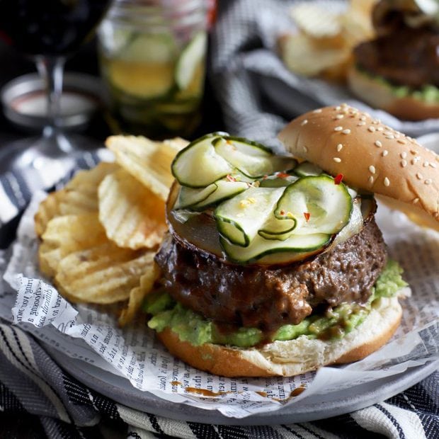 Burger with pickles, avocado, and chips