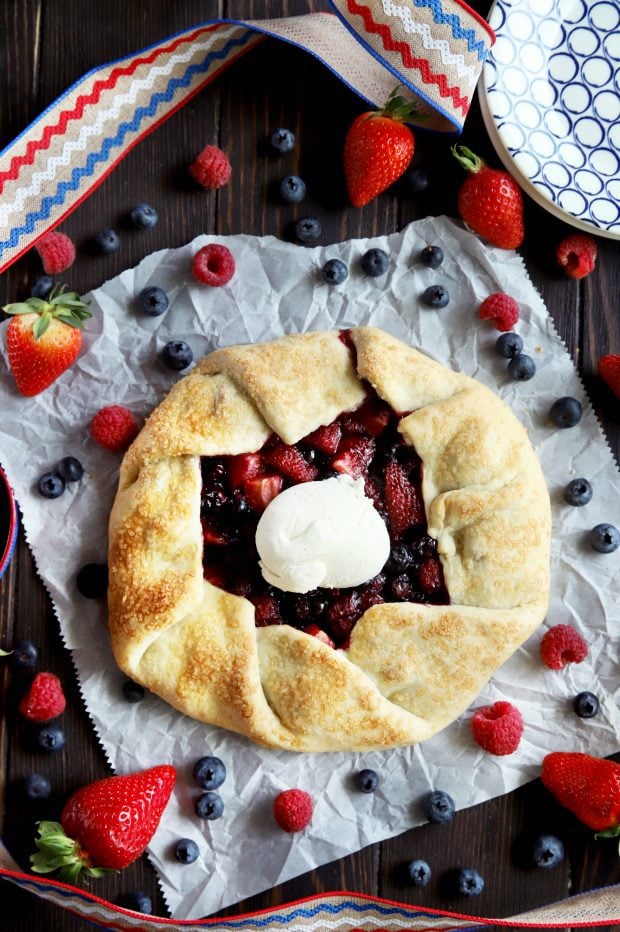 A red white and blue galette with berries on parchment paper