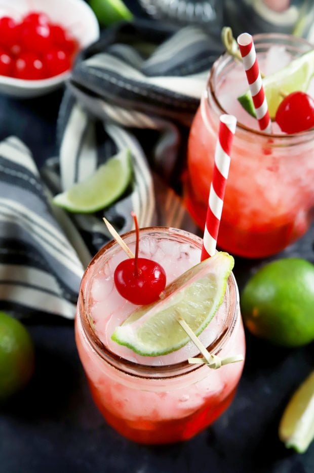 Overhead shot of summer cocktails with cherries and lime