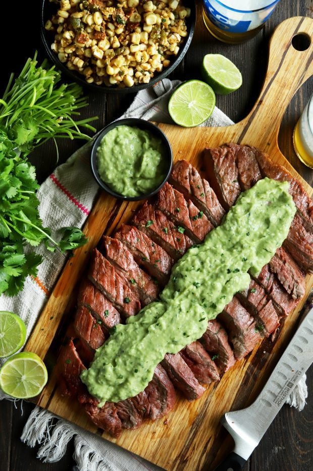 Sliced flank steak with creamy avocado salsa on top