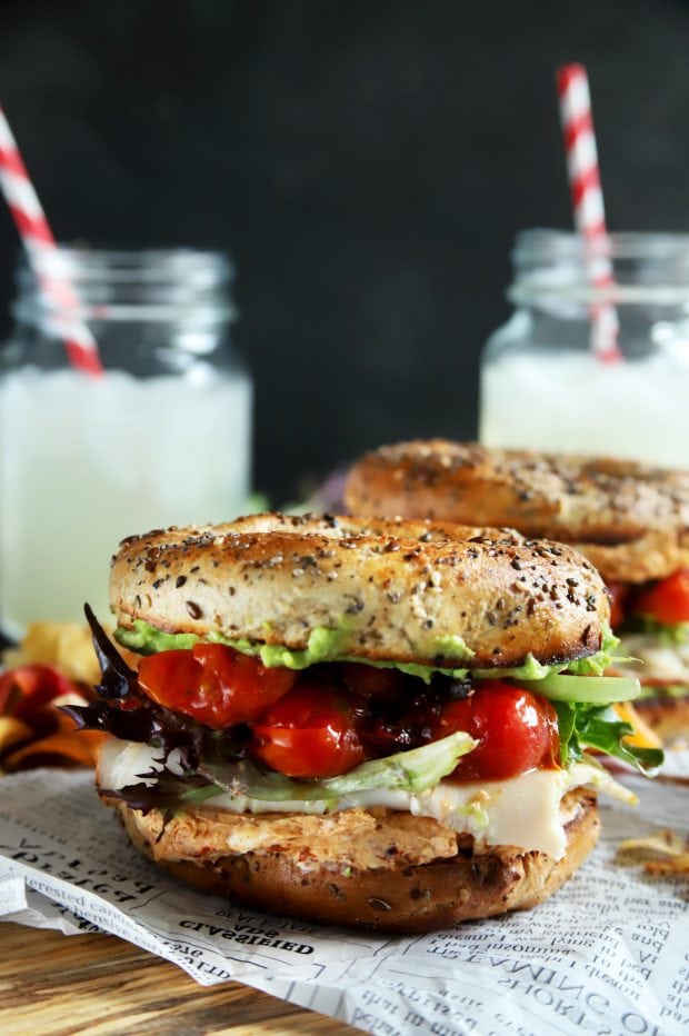 Healthy turkey bagel sandwich with avocado and tomatoes