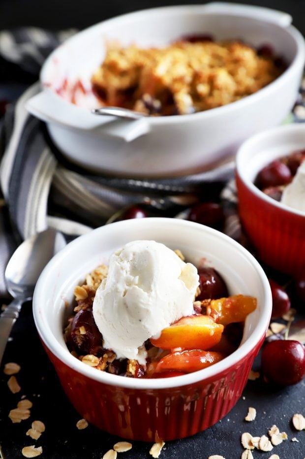 Individual cherry peach crumble desserts with ice cream