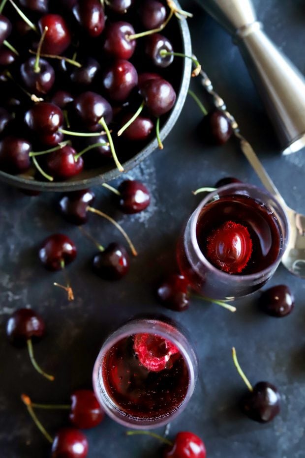 Fresh cherries with jigger, champagne glasses and mimosa cocktails