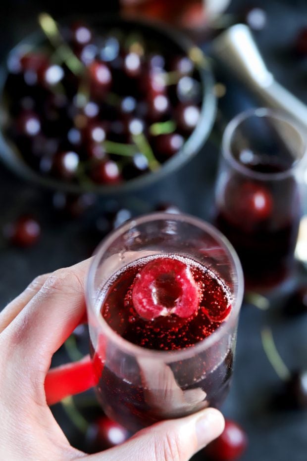 Overhead shot of a hand holding a champagne flute with a mimosa